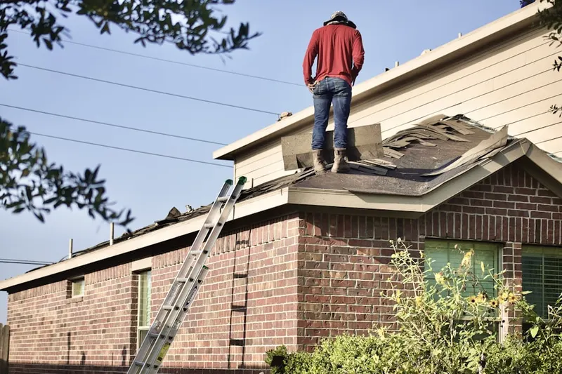 Professional roofer working on a residential roof in Needham Heights